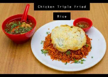Chicken triple fried rice topped with a fried egg